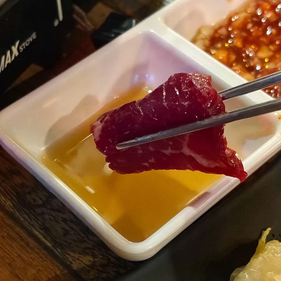 A piece of mungtigi dipped in sesame oil salt sauce
