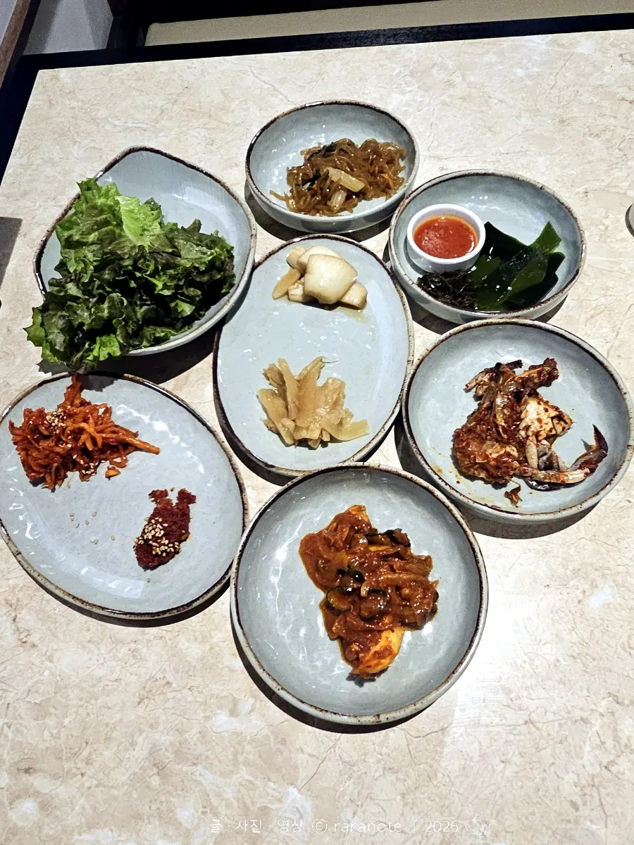 A spread of basic banchan including japchae, soy crab, and herring roe