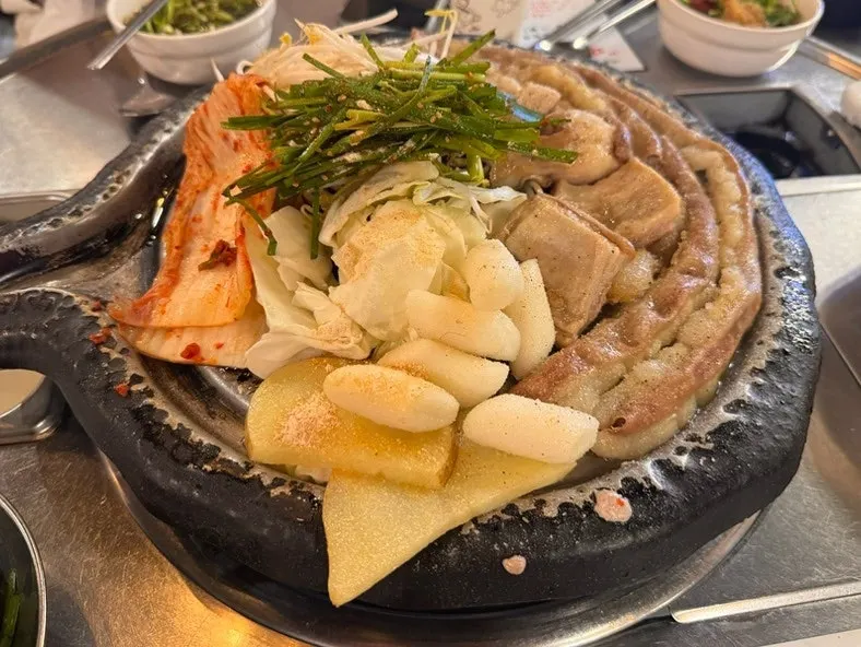 Full plate of gopchang, vegetables, and rice cake