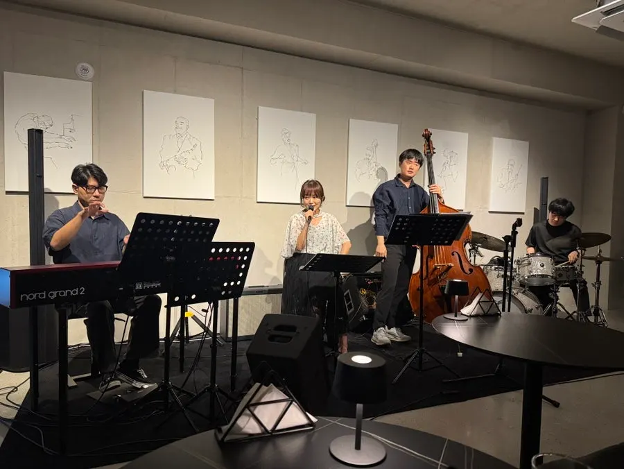 Live performance with piano, vocals, bass, and drums