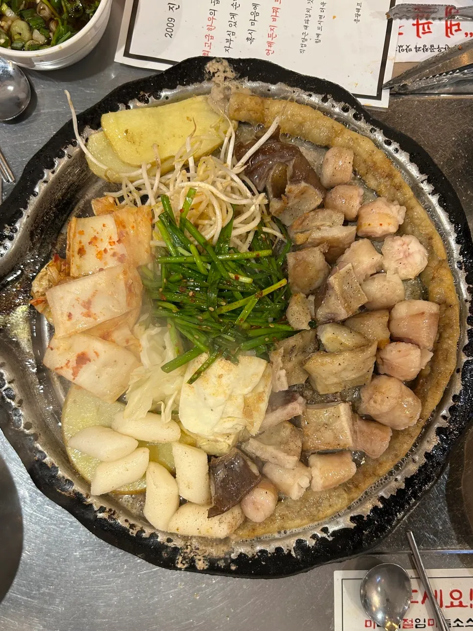 Gopchang and rice cake on the griddle before cutting