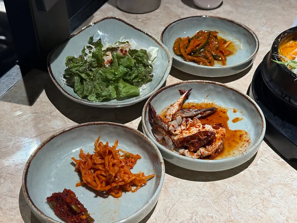 Banchan including marinated crab and japchae