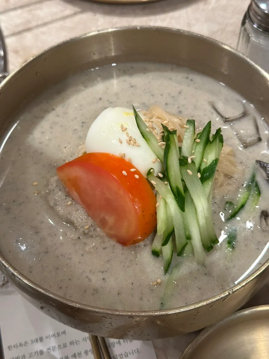 Kongguksu topped with tomato and cucumber