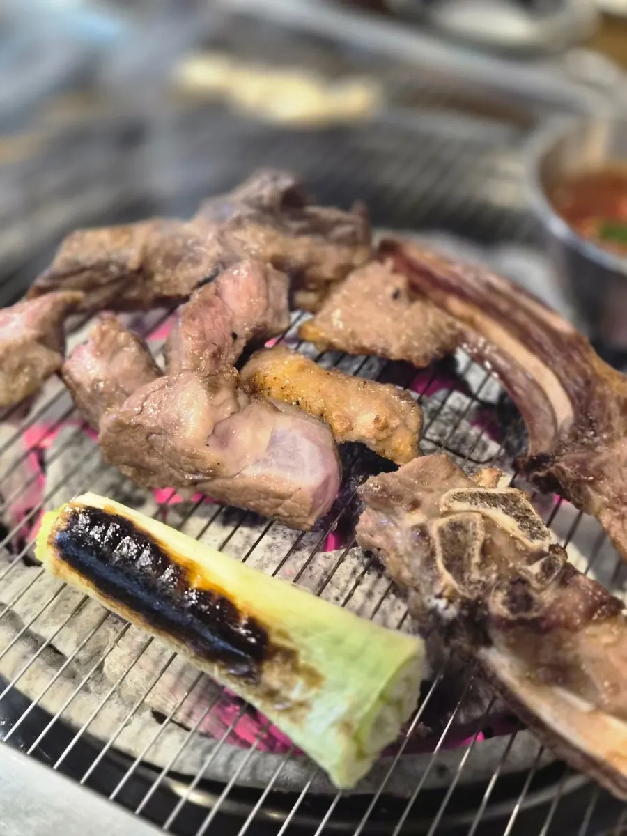 Lamb ribs grilling over charcoal