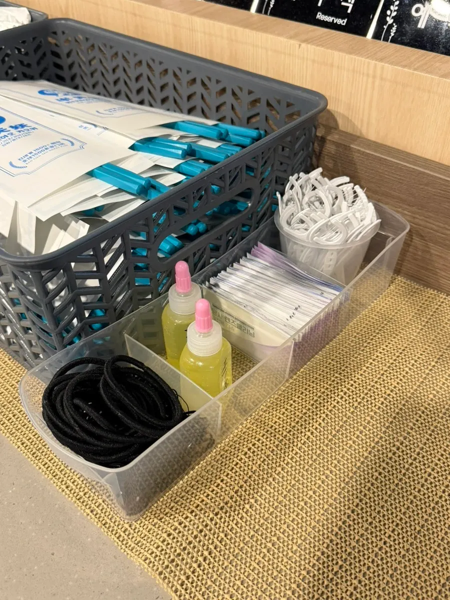 Shelf with phone charger, hair ties, and other amenities