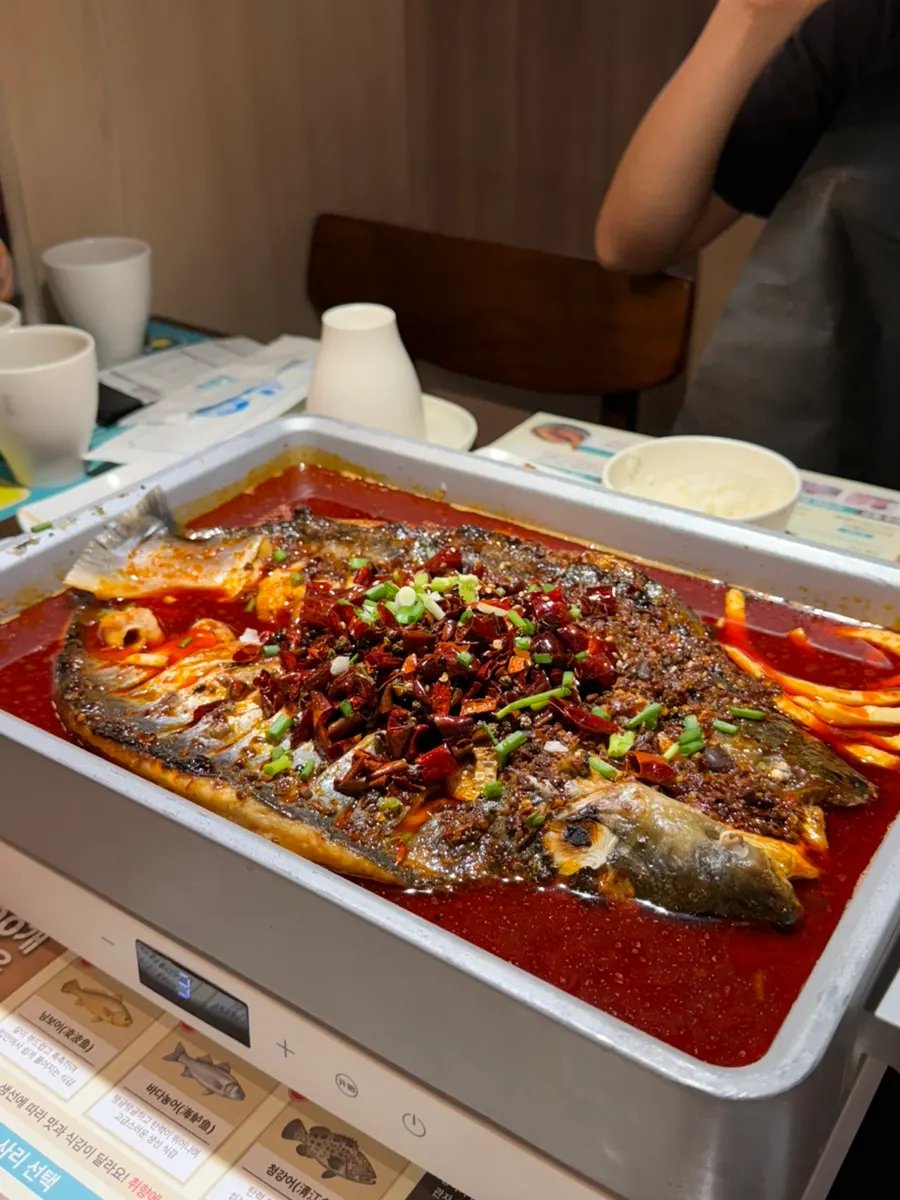 A full tray of mala kaoyu topped with red chili peppers