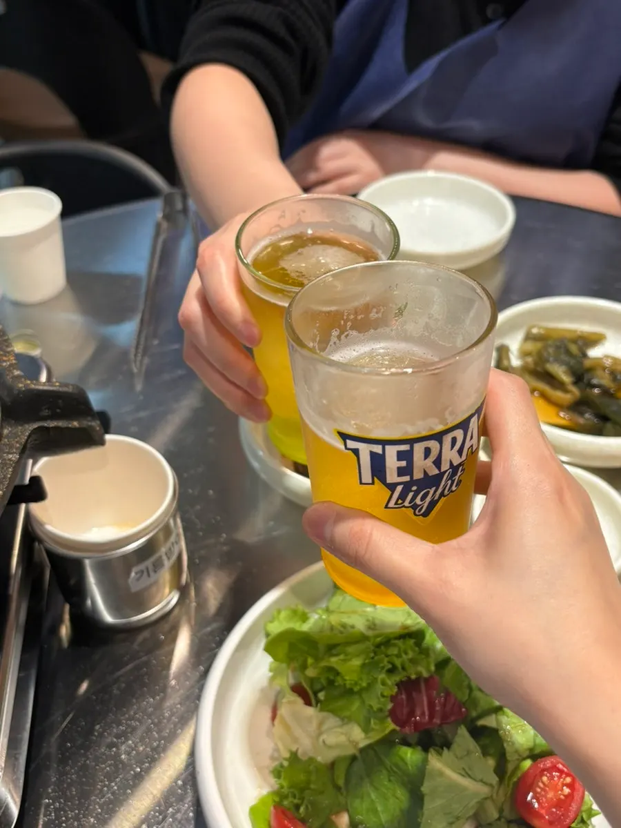 A glass of beer alongside grilled usamgyeop