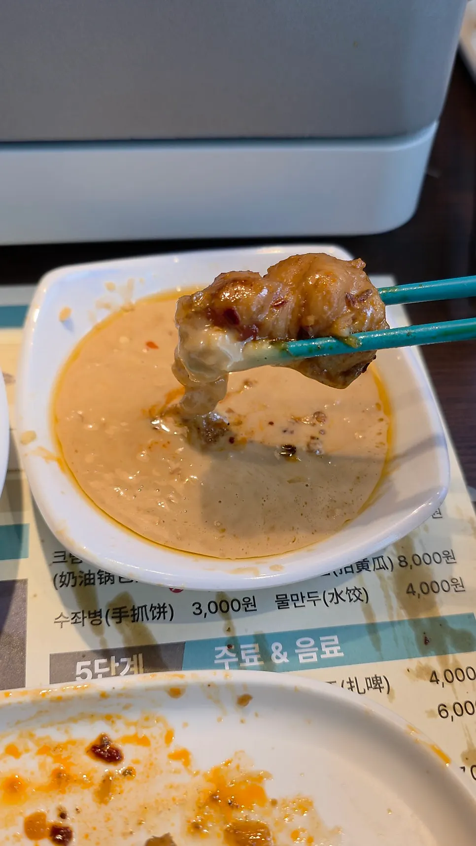 A piece of kaoyu fish dipped in sauce