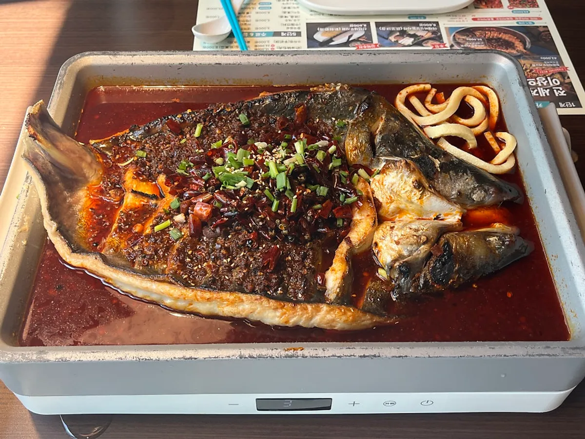 A pot of mala kaoyu with a large fish inside