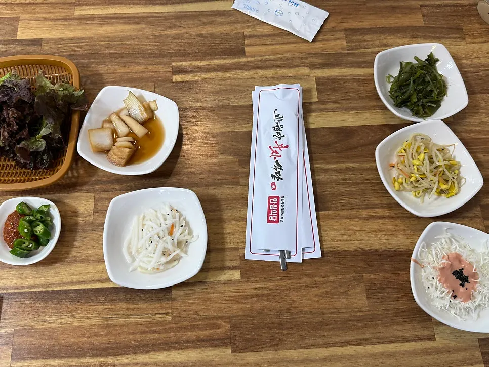 Side dishes including pickled onion and seasoned greens
