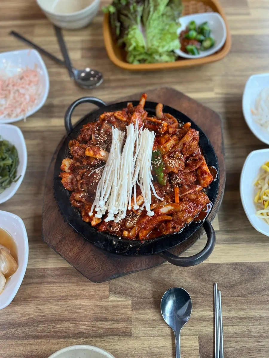 Fire-grilled squid-pork combo sizzling on the stone plate