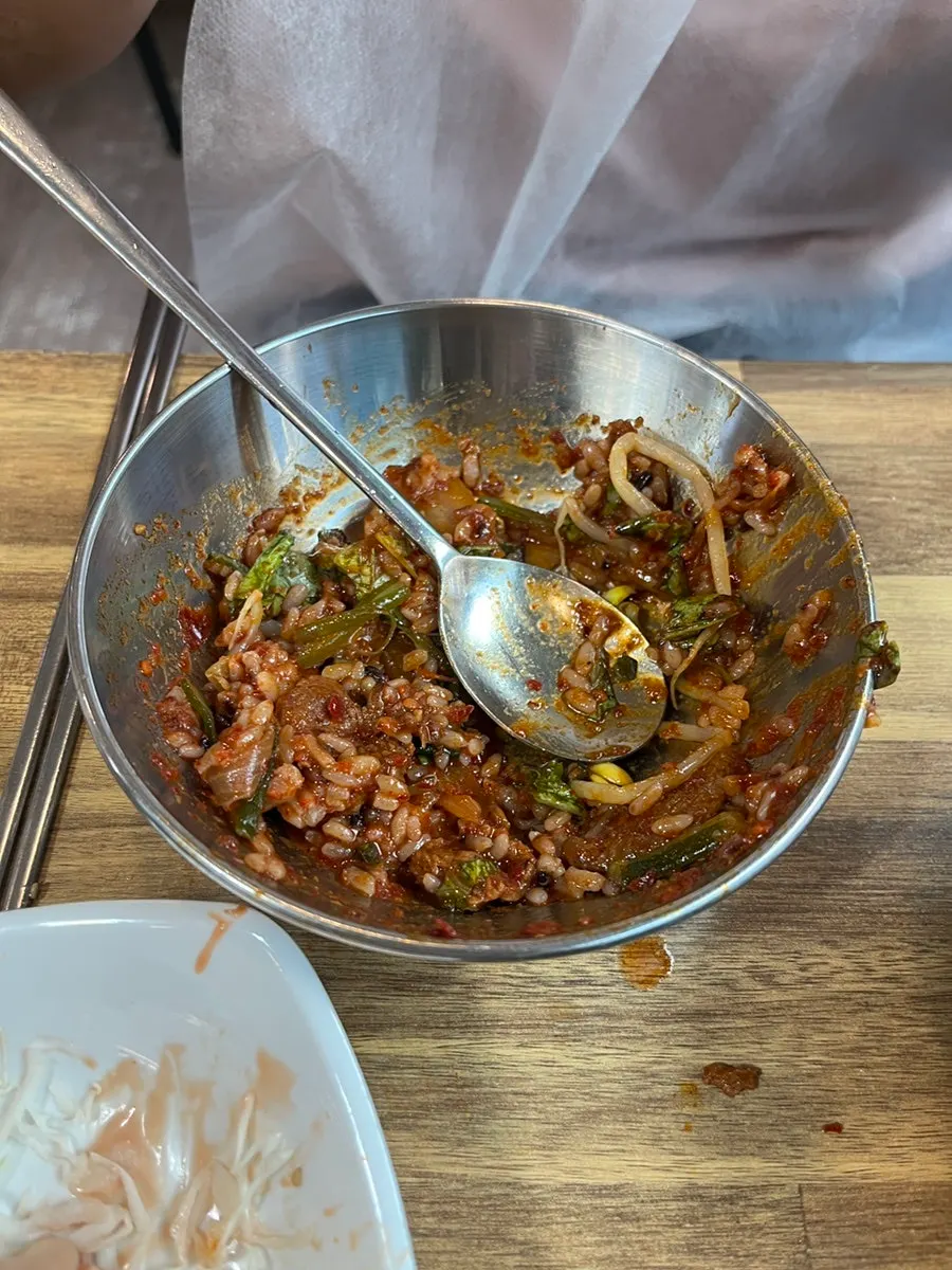 Mixing side dishes and rice into the squid-pork combo