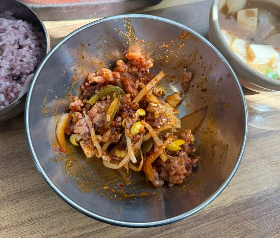 A lettuce wrap topped with meat and enoki mushrooms