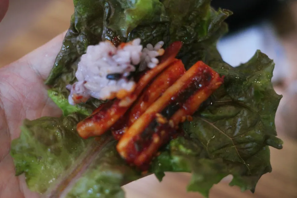 Lettuce wrap with rice and squid piled on top