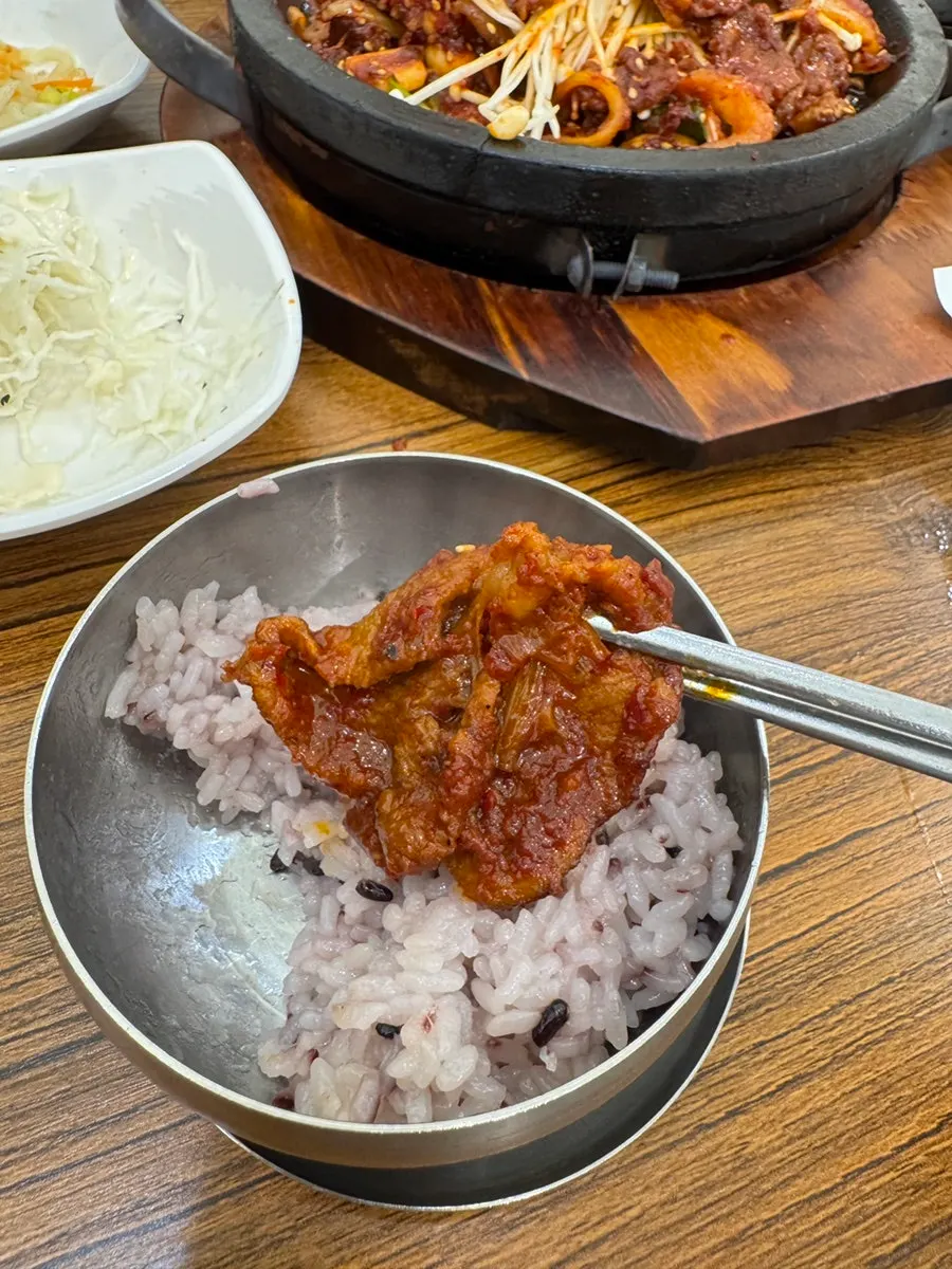 흑미밥 위에 올린 제육 한 점