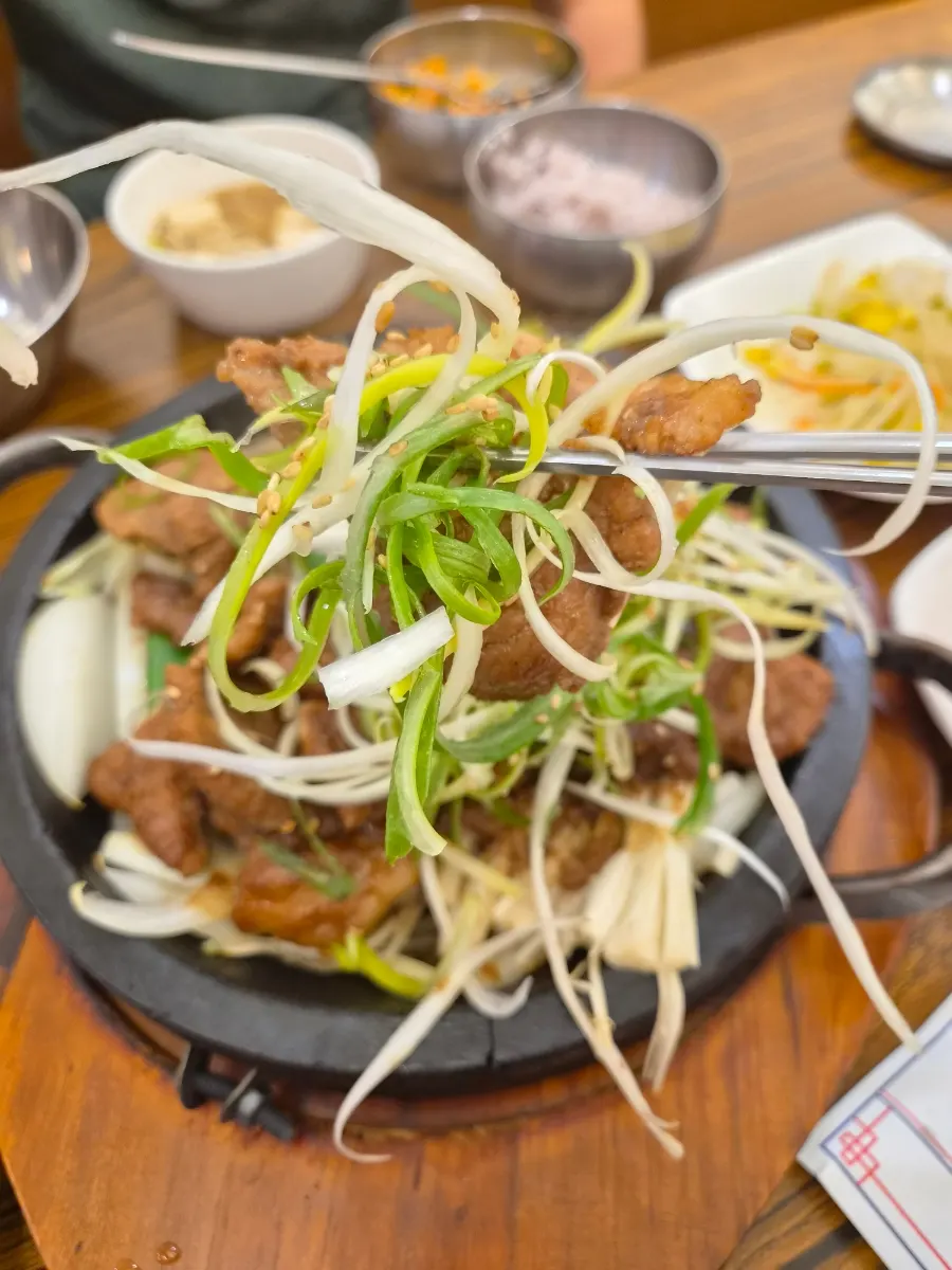 A piece of seokgalbi with enoki mushrooms and onions
