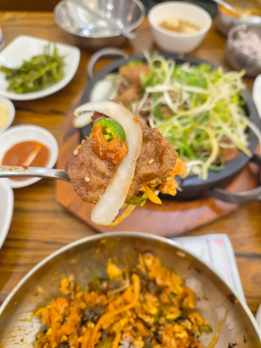 A piece of seokgalbi placed on top of the mixed bibimbap
