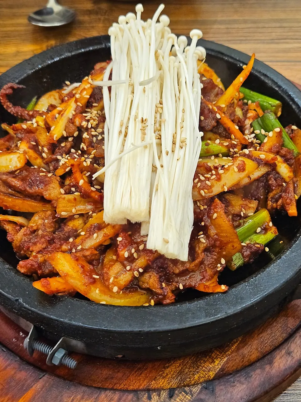 Fire-grilled squid pork stir-fry sizzling on the stone plate