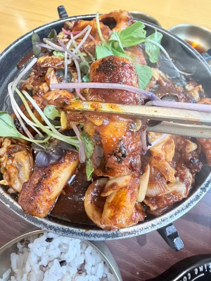 A piece of jjukkumi dipped in sauce