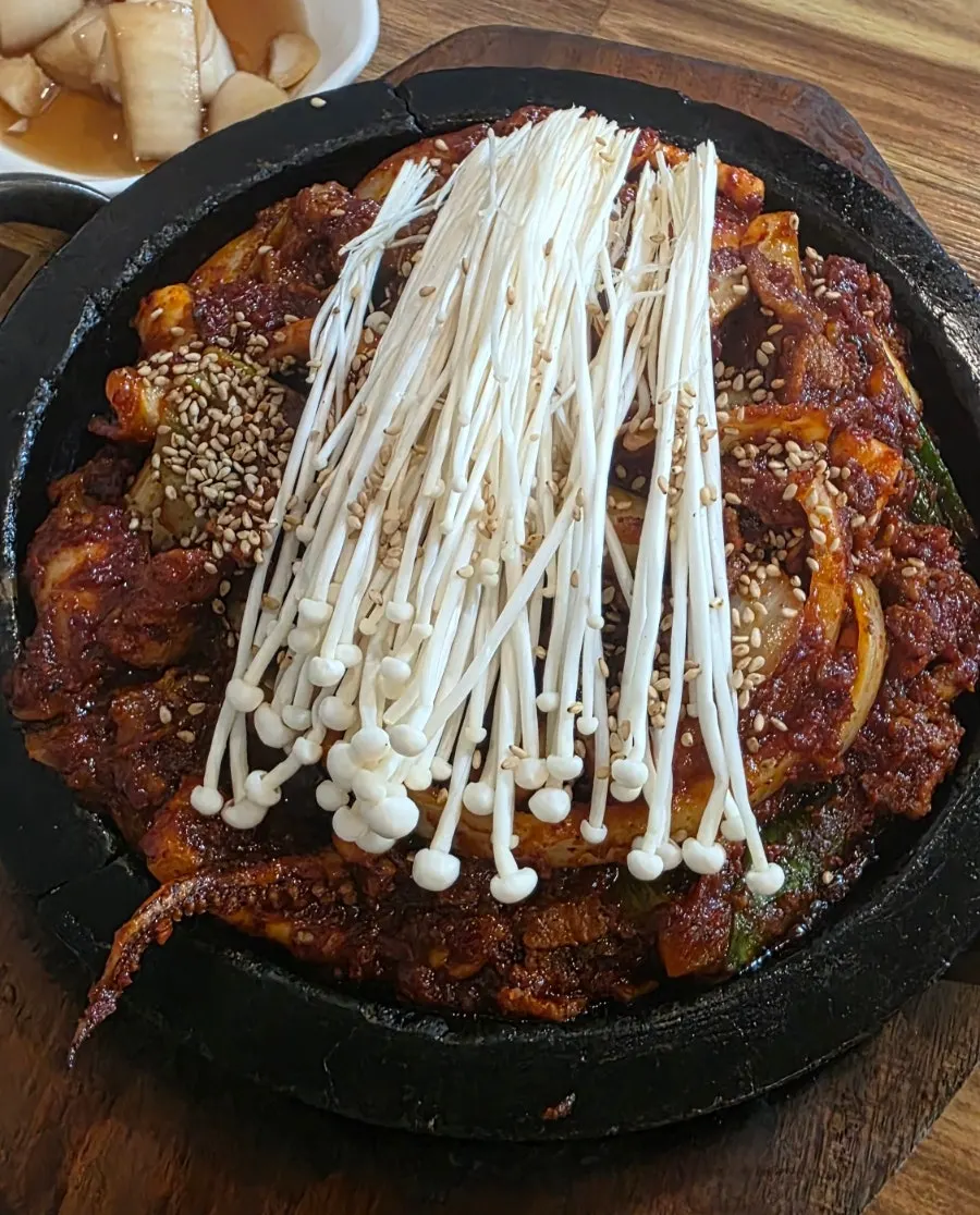 铺满金针菇的石板直火乌贼猪肉炒