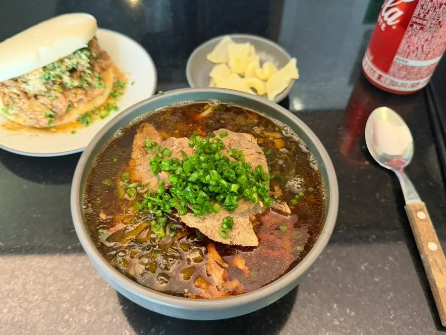 A bowl of Taiwanese beef noodle soup piled with meat