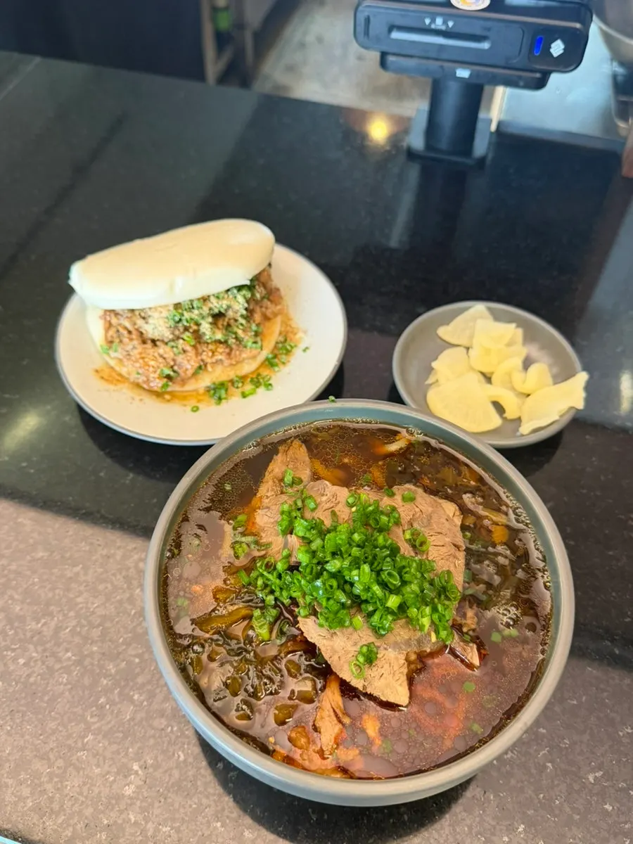 Full shot of beef noodle soup and classic bao