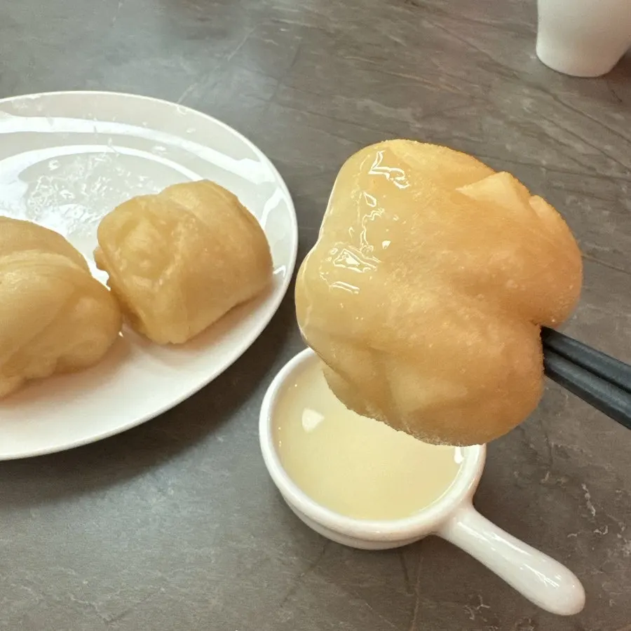 Flower bread being dipped into condensed milk