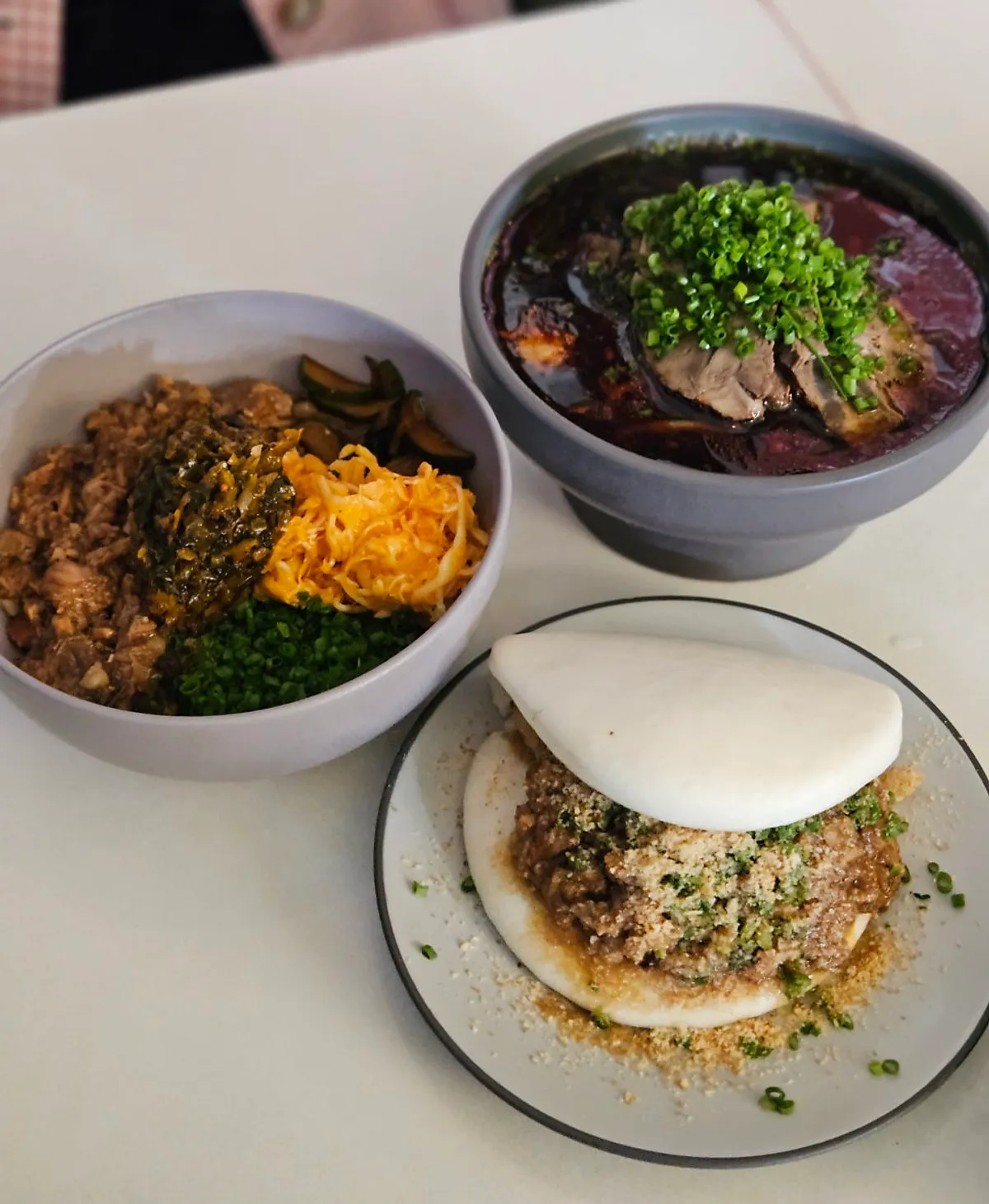 Classic bao, beef noodle soup, and braised pork rice bowl on the table
