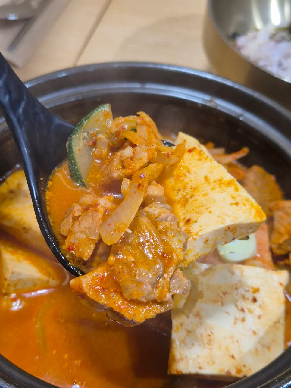 Spoonful of ingredients scooped from the kimchi jjigae