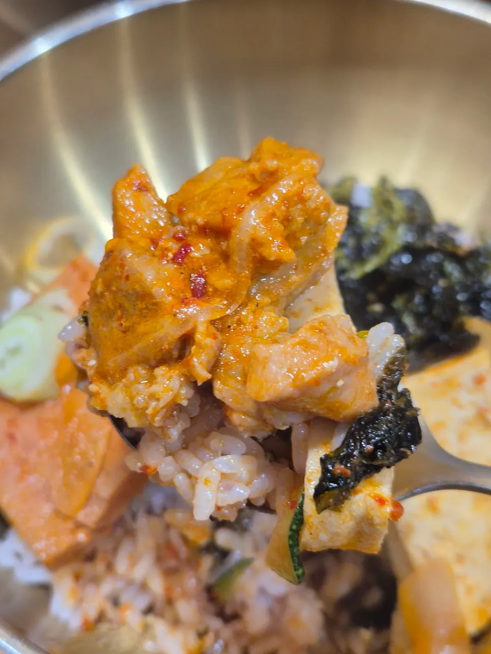 Kimchi jjigae served with rice topped with seaweed flakes