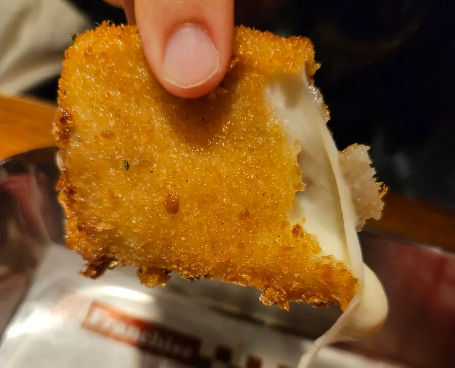 Cheese flowing out from the crispy batter of the mozza cheese bar