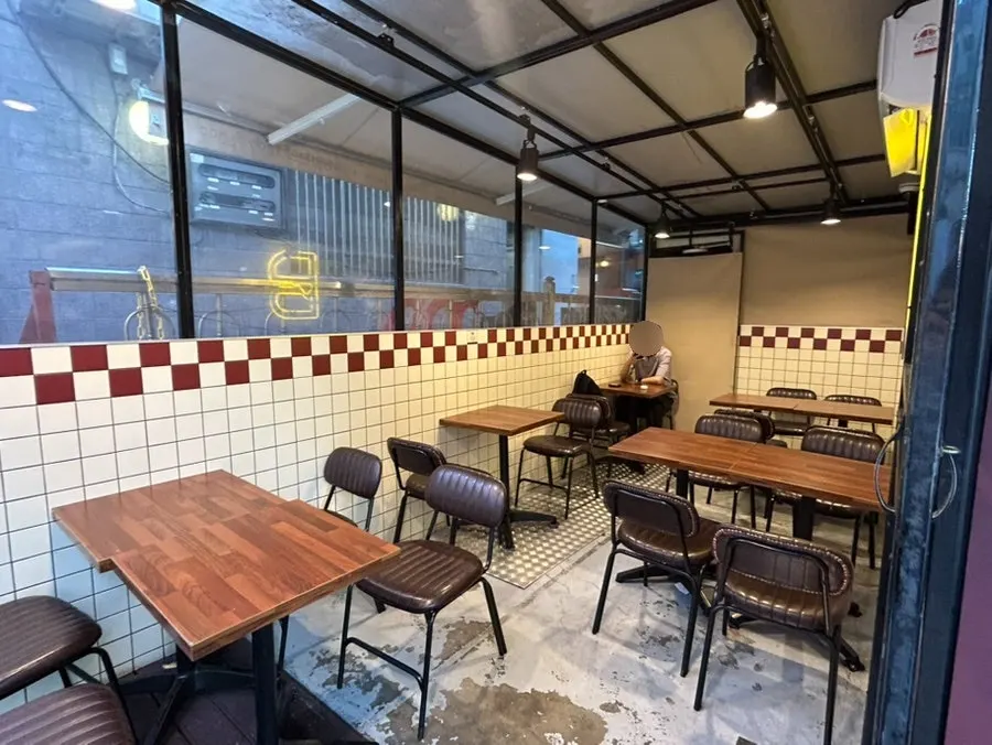Store seating with red-and-white tile and wood tables