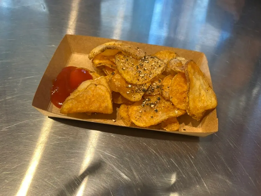 Close-up of potato chips sprinkled with cracked black pepper