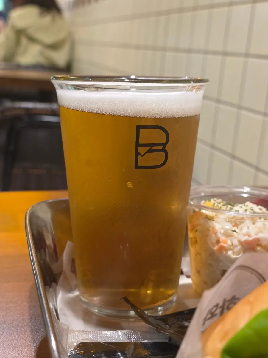 A cold glass of draft beer paired with the burger