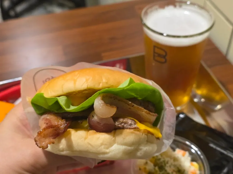 Cross-section of the burger showing patty, cheese, bacon, and vegetables