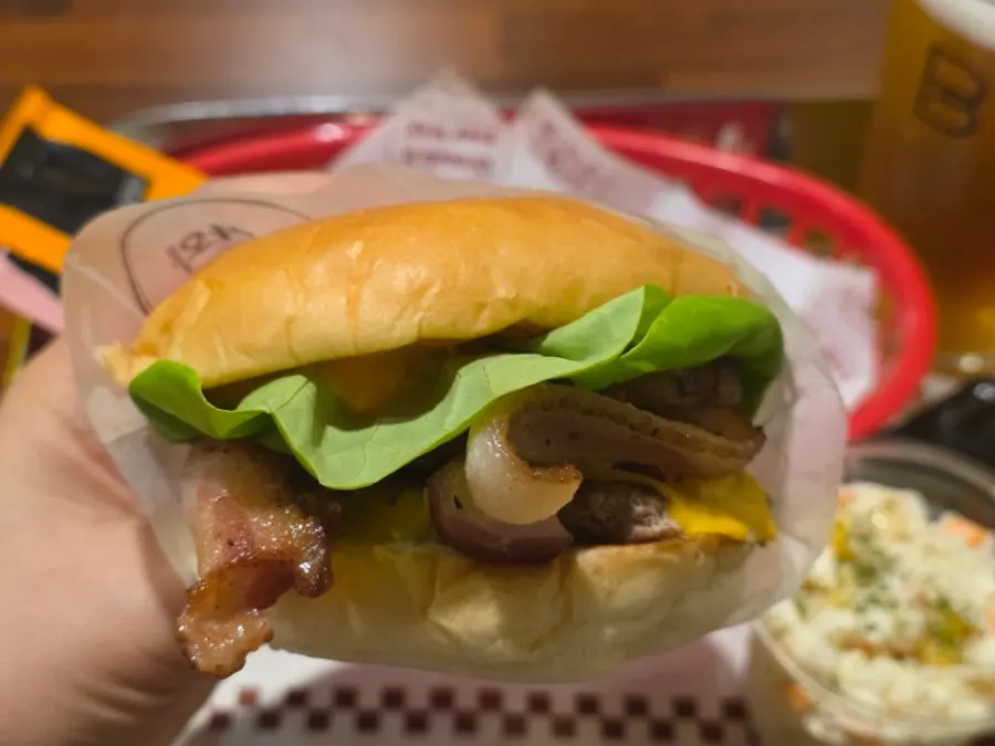 A bite of the Hawaiian burger with a glass of draft beer