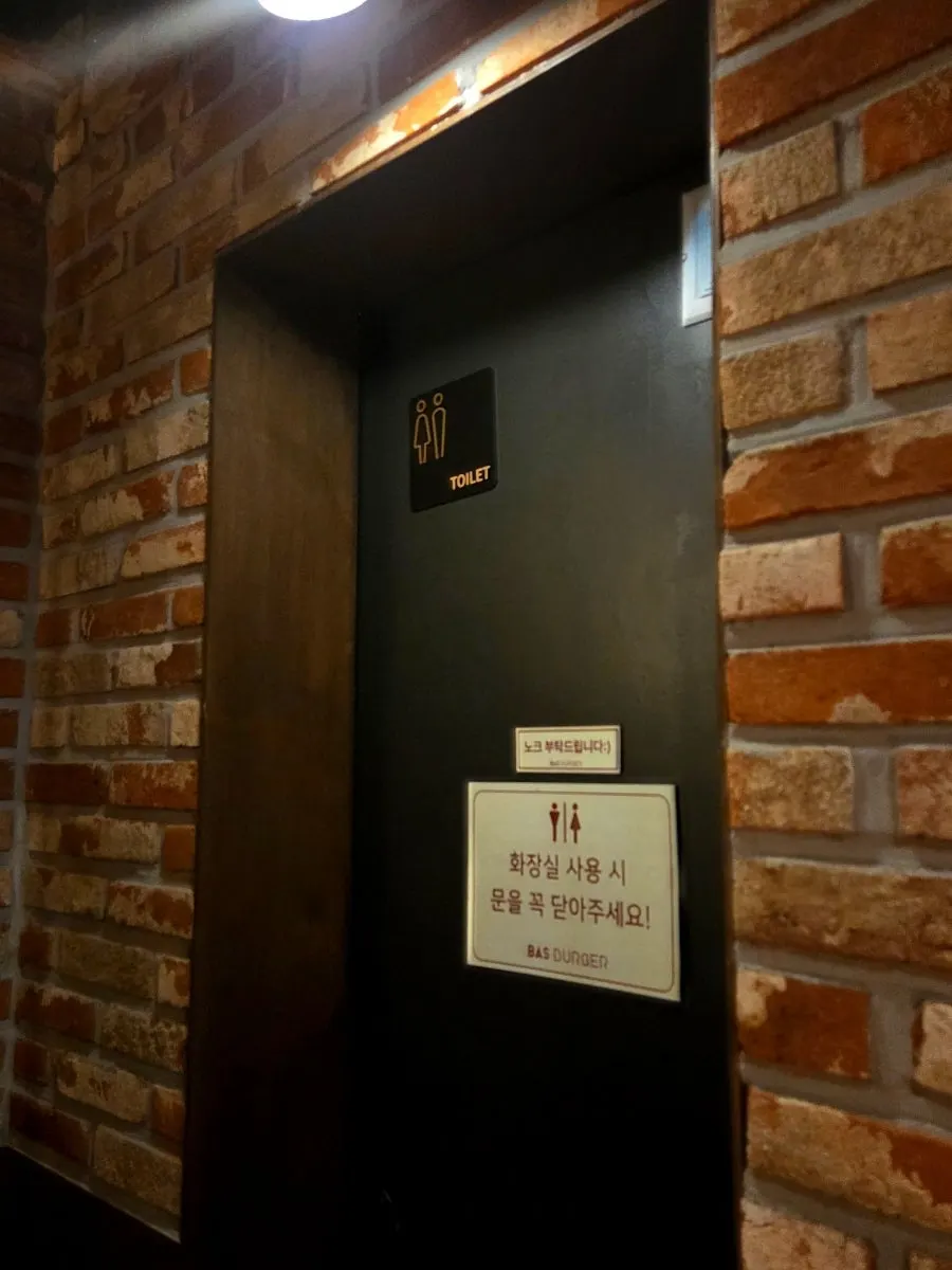 Sign indicating a restroom inside the store