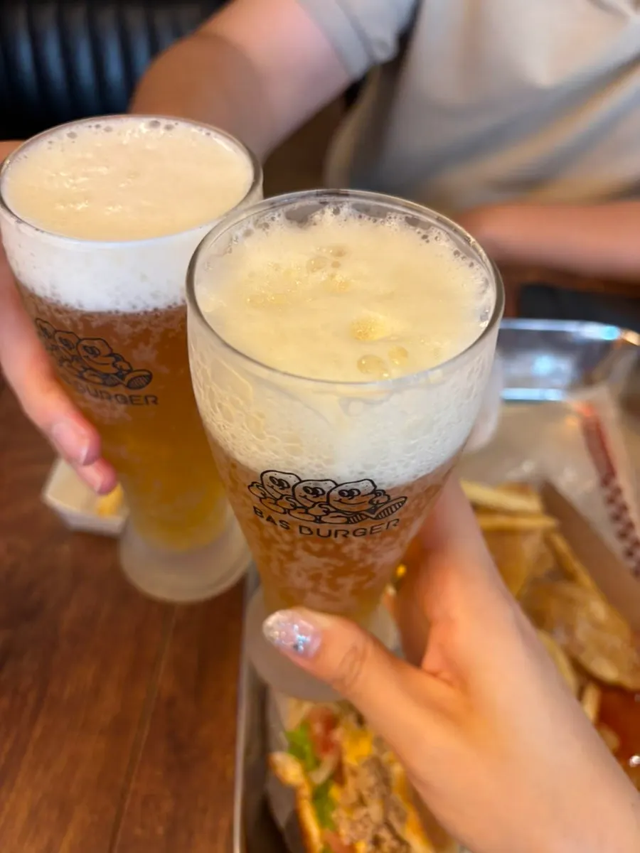 Burgers and beer laid out on the table together