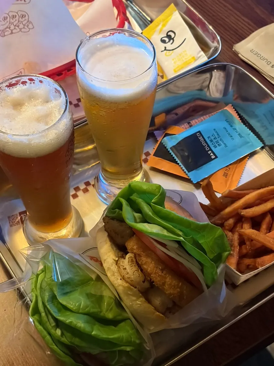 Table set with burgers, sides, and beer