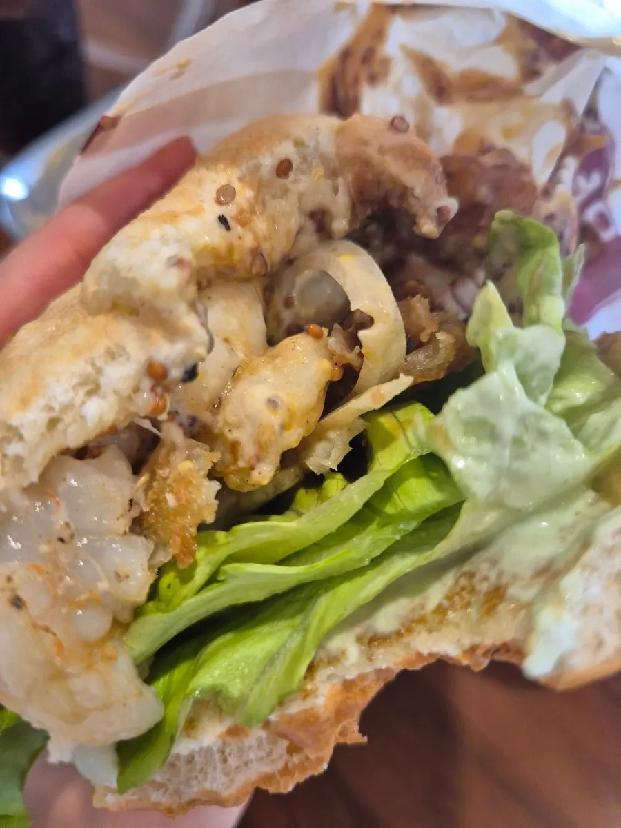 A bite taken out of the Wasabi Mayo Shrimp Burger