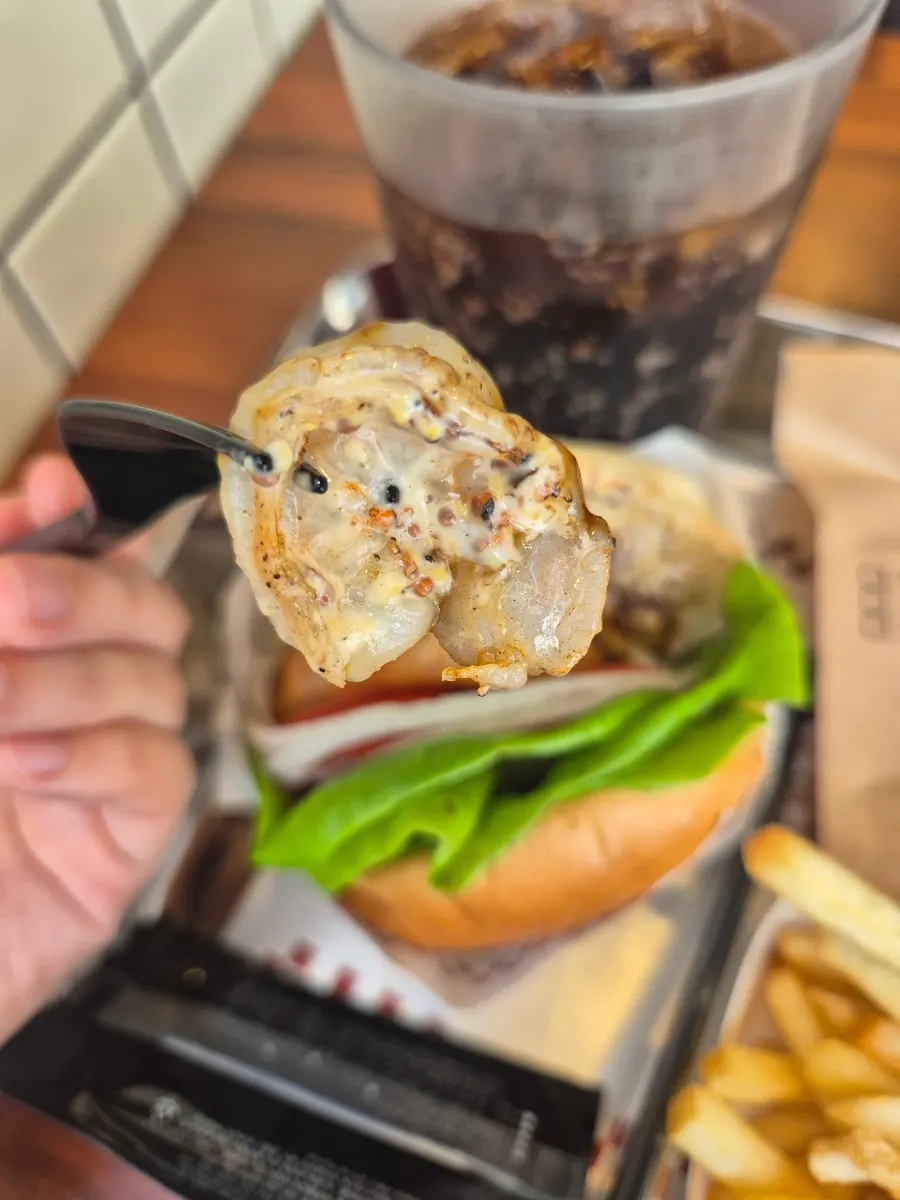 Cross-section of a bite showing the whole shrimp in the burger