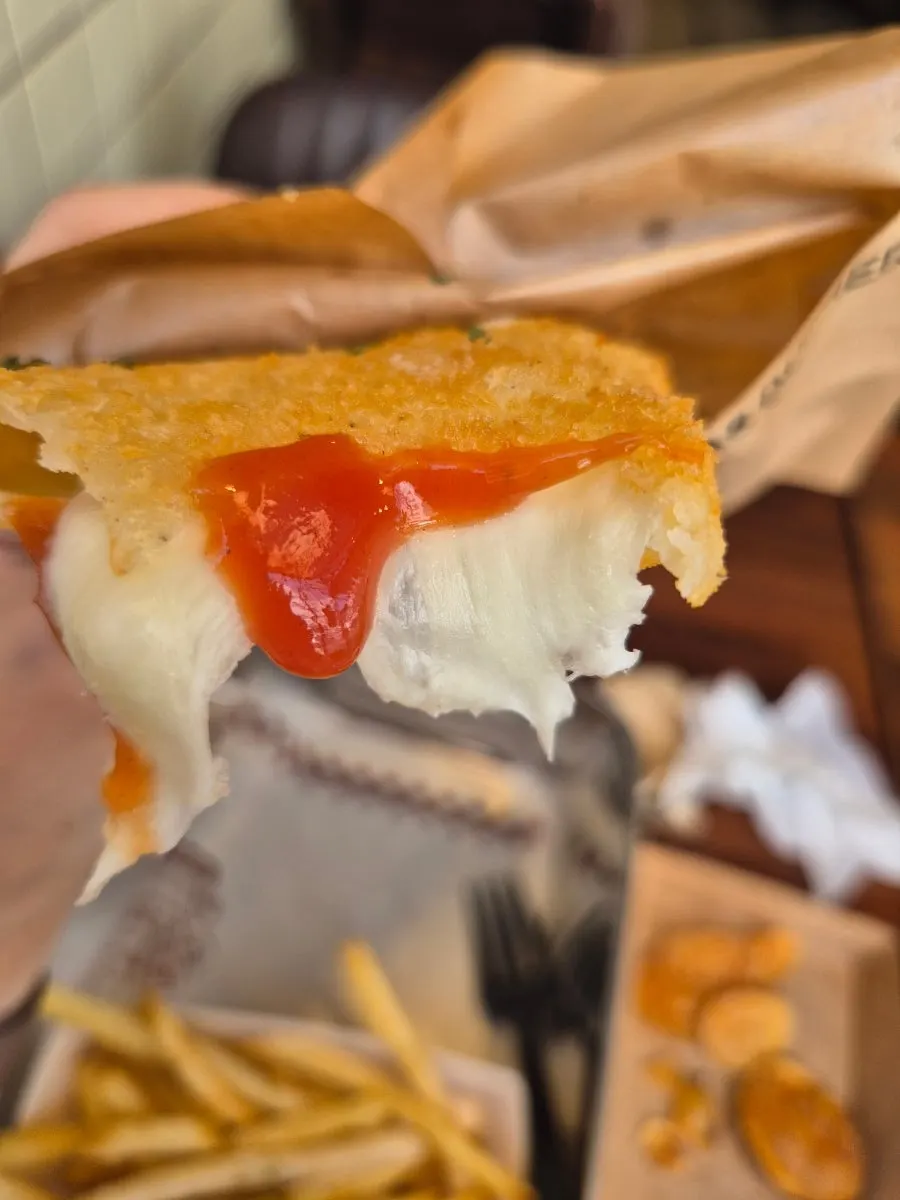 Mozzarella cheese stretching long from the cheese bar