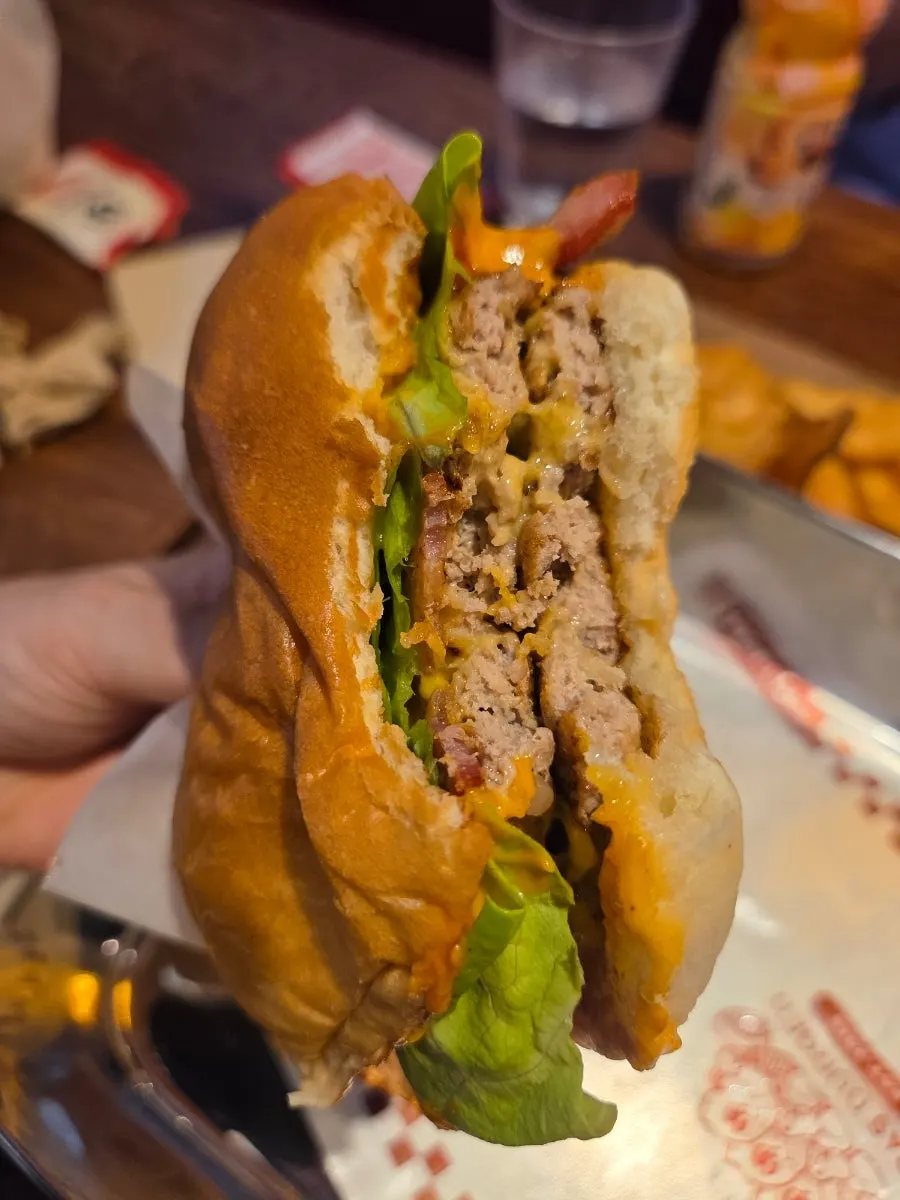 Cross-section of a handmade burger held in hand