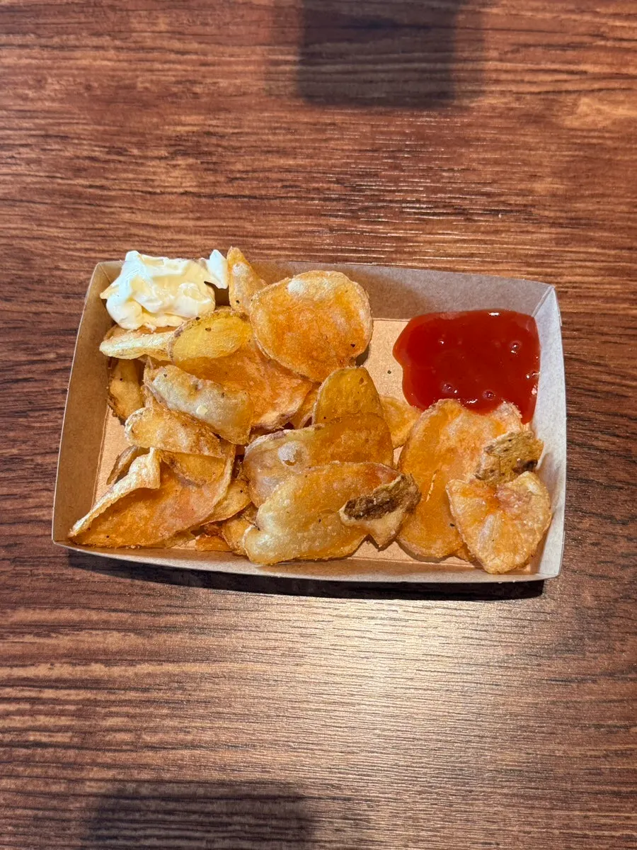 Warm potato chips scooped into a cup
