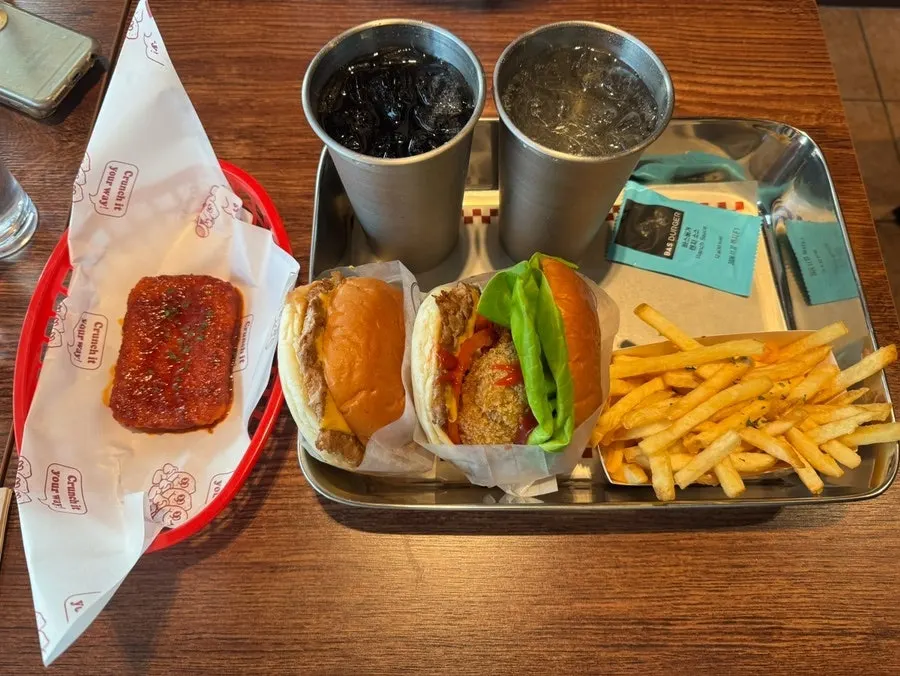 Two burgers and a chilli mozza cheese bar on a tray