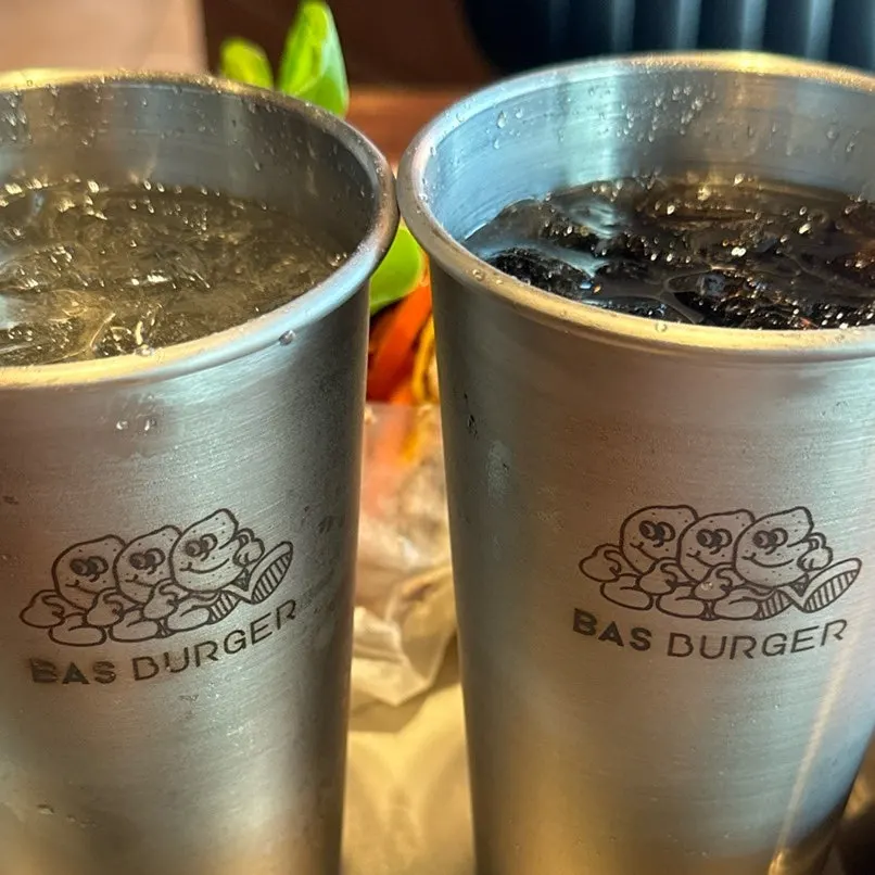 Cider and cola cups printed with the Base Burger logo