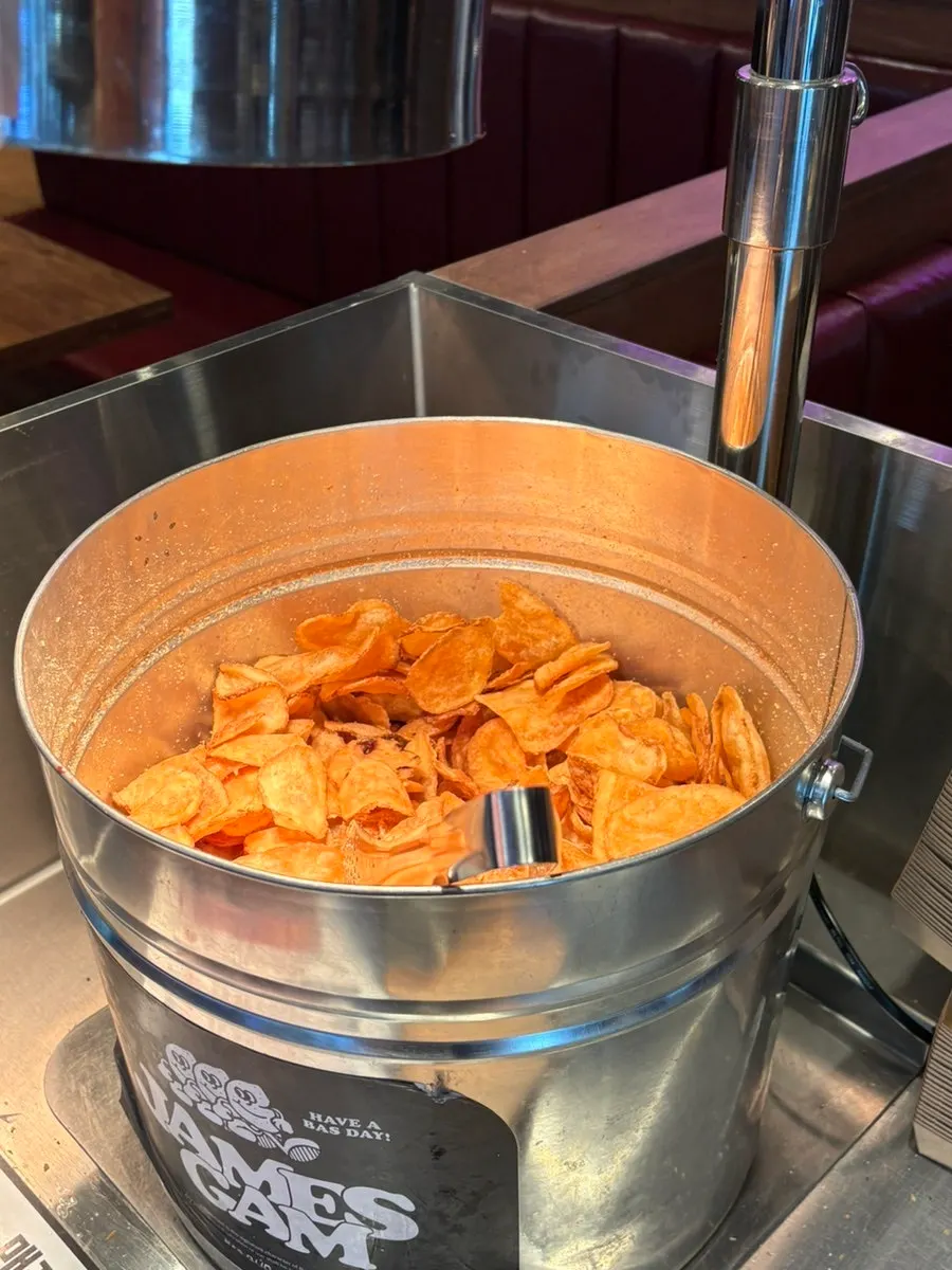 Free chips piled in a basket under a warmer