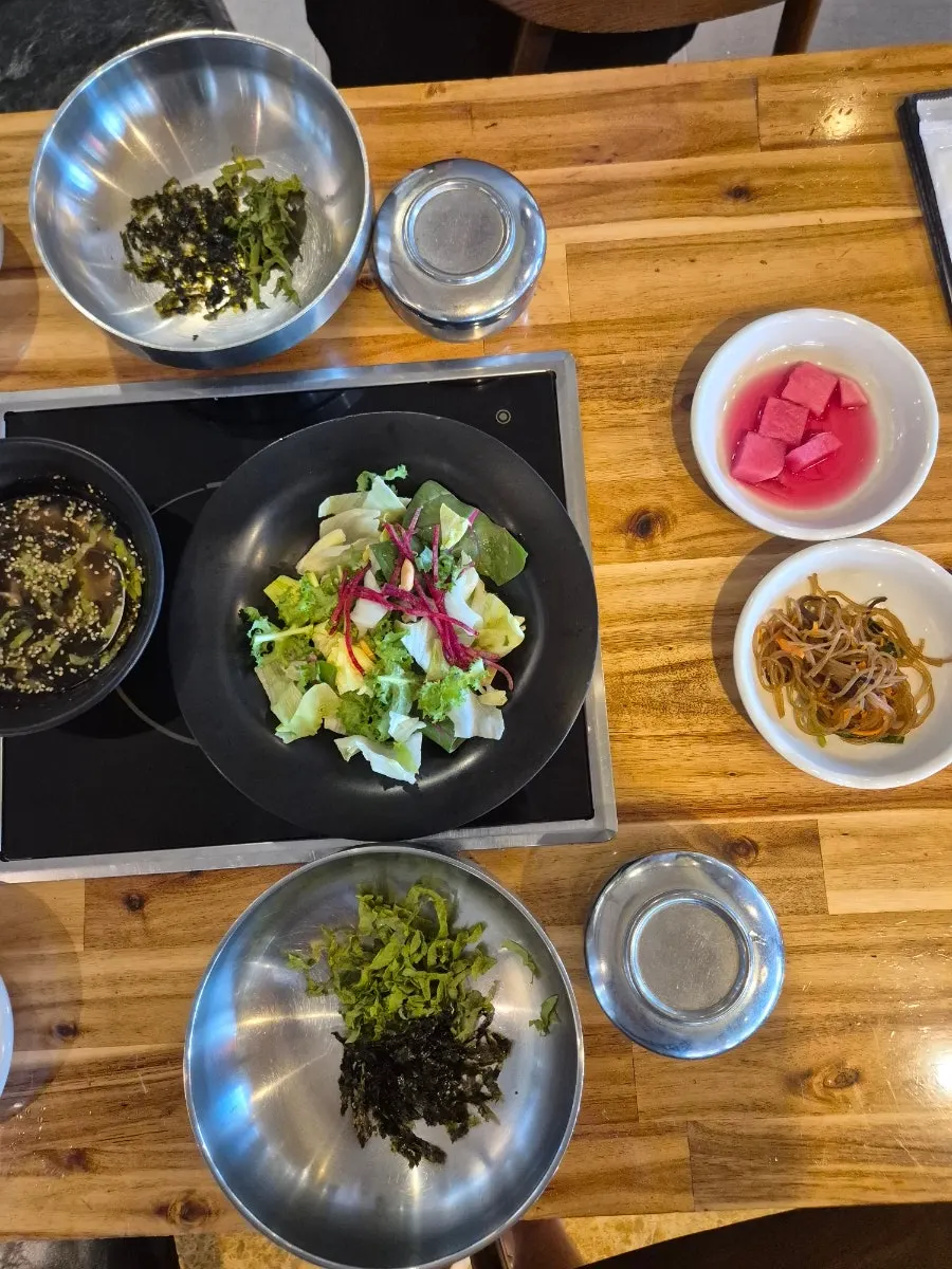 Spread of side dishes including mukbap and japchae