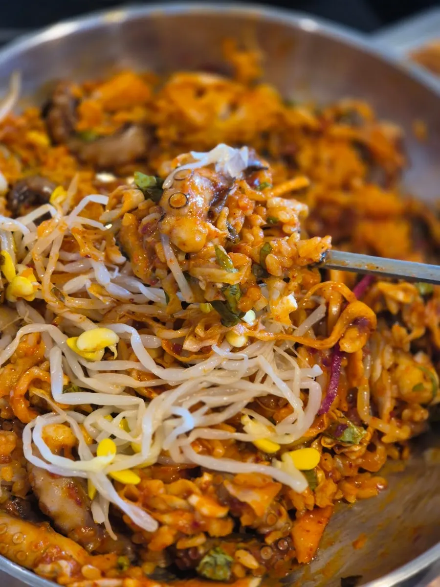 A spoonful of bibimbap with octopus and bean sprouts