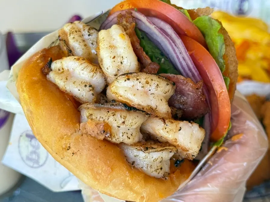 A bite taken out of the Grilled Shrimp Avocado burger
